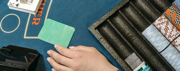 Bàn Blackjack nỉ xanh với lá Át và lá K tạo thành 21 cùng chồng phỉnh cược và bài của nhà cái